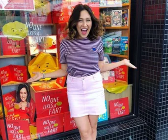 Author in front of a bookstore display of "No One Likes a Fart" with excitement.