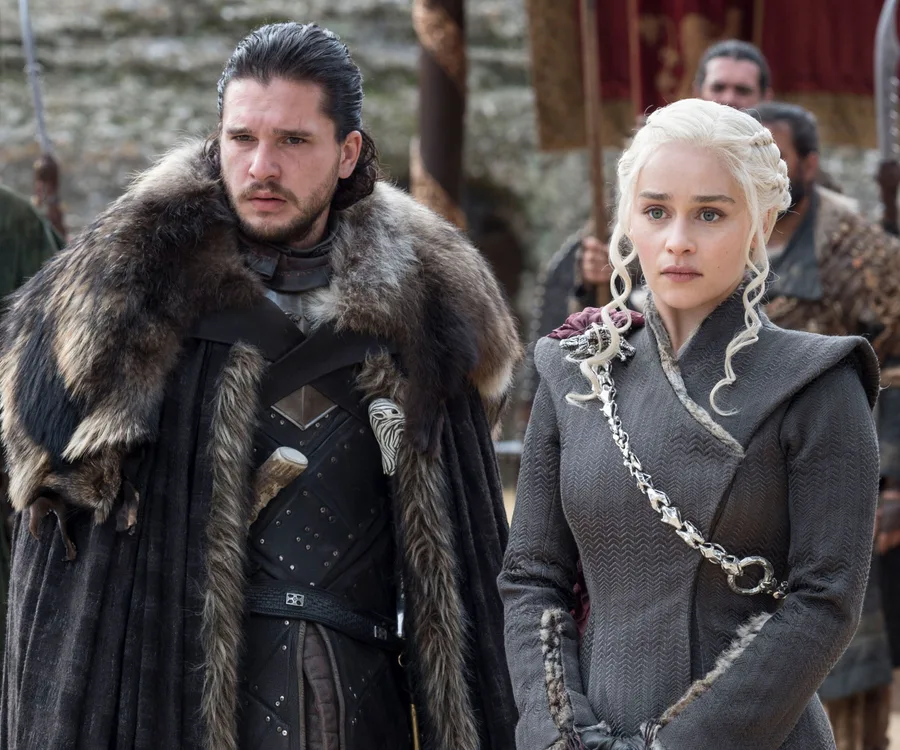 Two characters from Game of Thrones dressed in winter attire, standing outdoors with serious expressions.