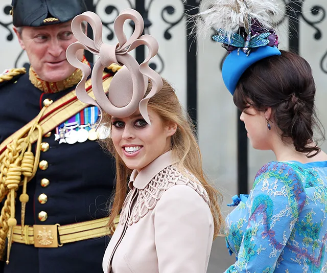 Guests wearing elaborate hats at a royal wedding.