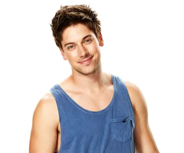 Person in a blue tank top smiling against a white background.