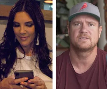 Woman looking at phone beside a man wearing a cap indoors.
