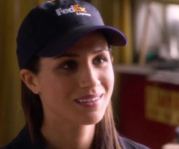 FedEx employee wearing a cap, smiling in a scene from "Horrible Bosses."