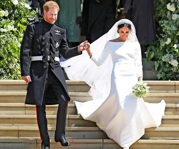 Royal wedding couple exiting chapel, bride in white gown holding bouquet, groom in military uniform, smiling and holding hands.