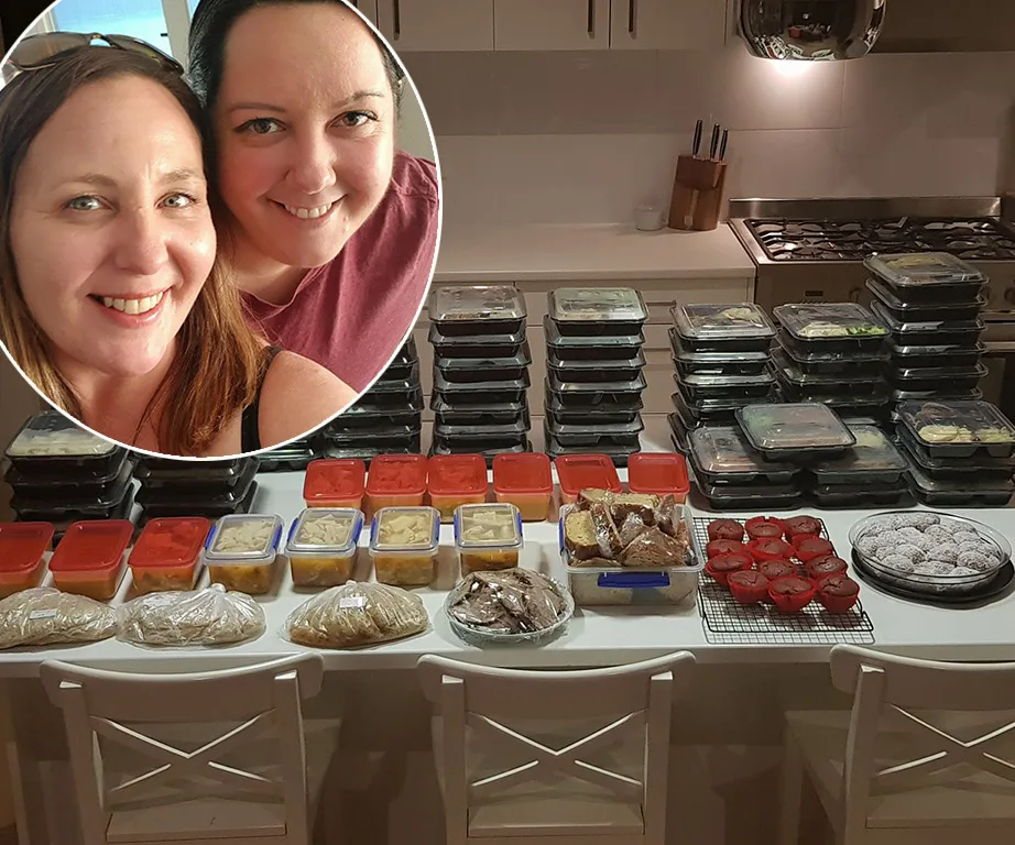 Two women smiling, with a kitchen counter full of meal prep containers in the background.
