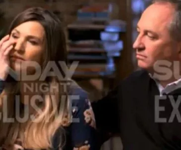 Couple sitting closely during an interview on "Sunday Night," overlaid with text "EXCLUSIVE."
