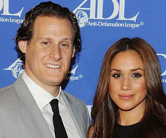 Man in a gray suit and woman in black dress posing together at an Anti-Defamation League event.