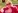 Elle Woods from "Legally Blonde," wearing pink sunglasses, a sparkly top, and a fur coat, smiles and waves outdoors.