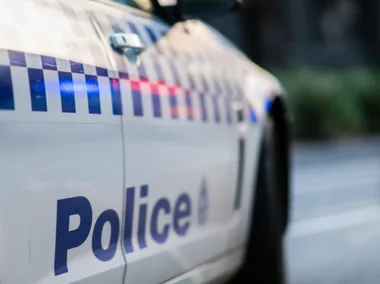 Police car with blue and red flashing lights on the side, indicating emergency response.