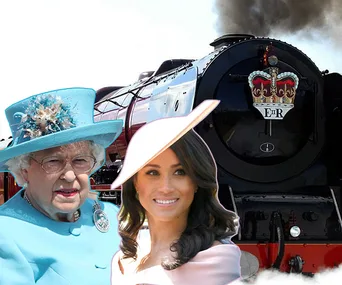 Two women in formal attire stand in front of a steam locomotive with an emblem.