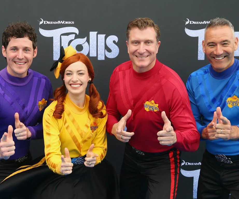The Wiggles posing together in colored outfits at a DreamWorks Trolls event.
