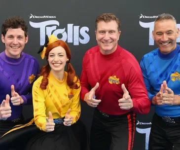The Wiggles posing together in colored outfits at a DreamWorks Trolls event.