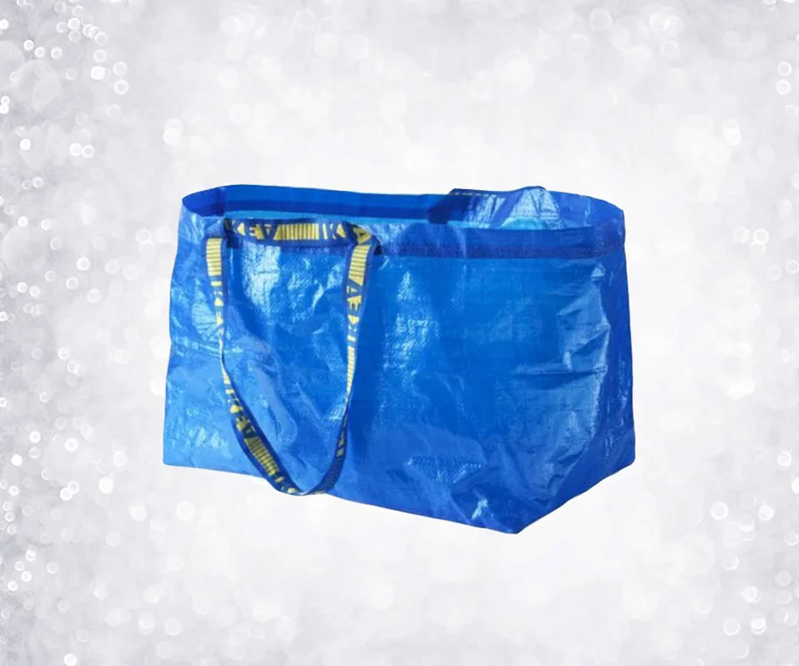A blue IKEA bag with yellow handles against a sparkling background.