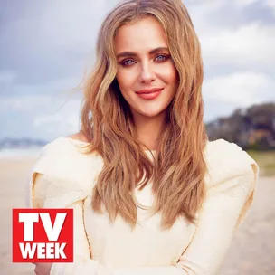 Smiling woman with long hair on a beach, wearing a light-colored dress; TV Week logo displayed in the corner.
