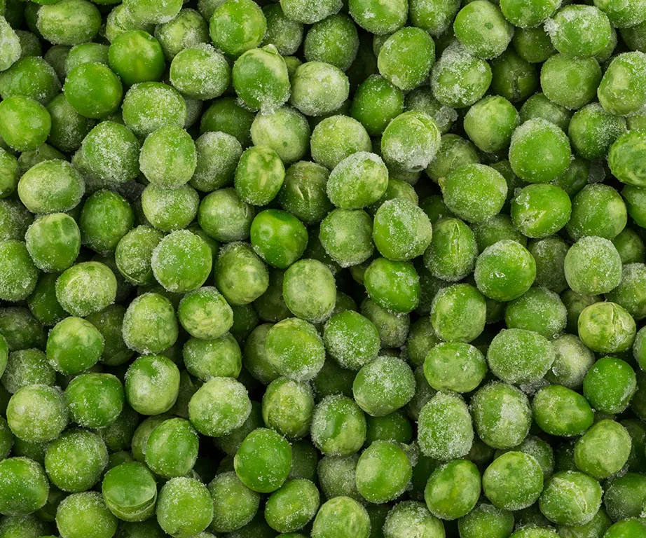 Frozen green peas covered in frost crystals.