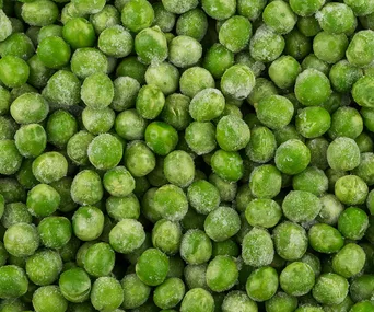 Frozen green peas covered in frost crystals.