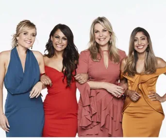 Four women from "The Single Wives" pose, wearing elegant dresses in blue, red, pink, and mustard colors on a white background.