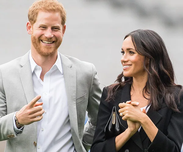 Man in gray suit and woman smiling, both outdoors, suggesting a public appearance or event.