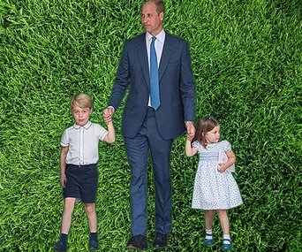 Man in suit holding hands with two children on grass background.