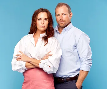 Couple poses confidently against a blue background; woman in white blouse and pink skirt, man in light blue shirt.