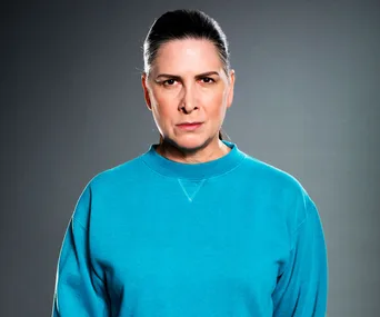 "Character in blue sweatshirt with serious expression against a gray background."