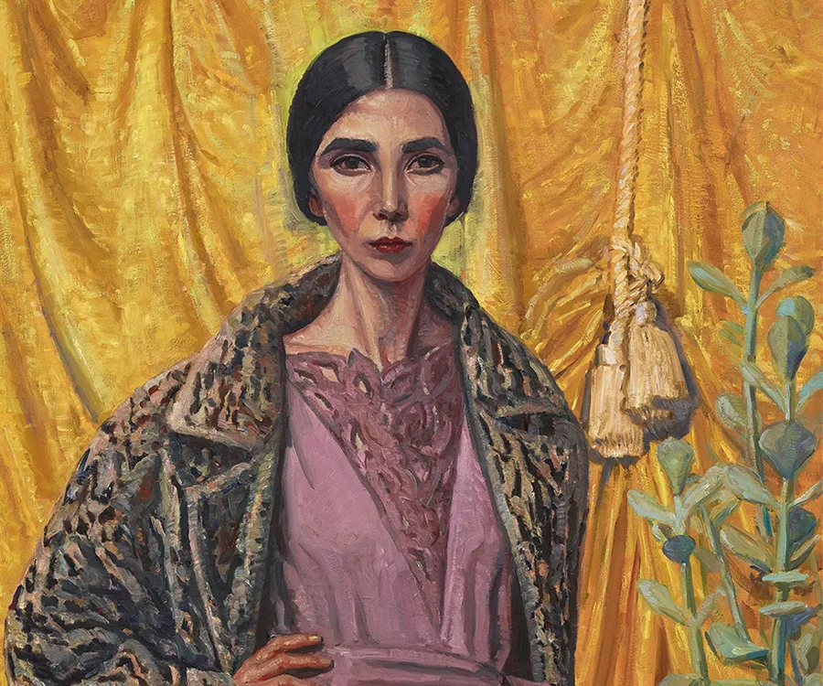 Portrait of a woman with dark hair, wearing a leopard print coat over a pink dress, against a gold draped background.