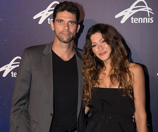 A couple posing on the red carpet at a tennis event.