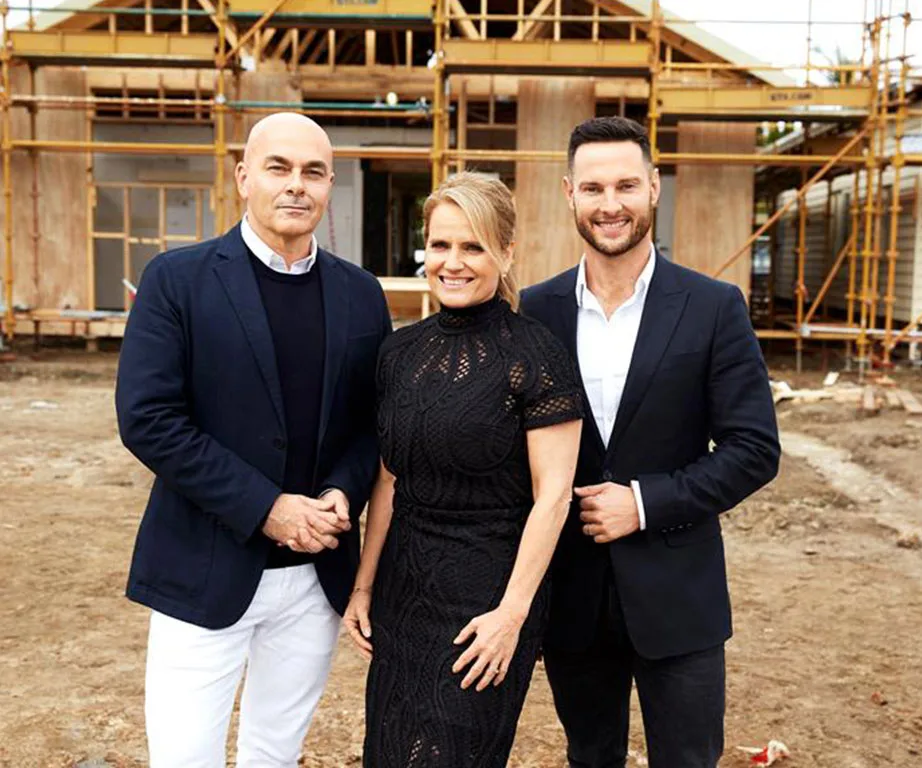 Three people in formal attire standing in front of a building under construction.