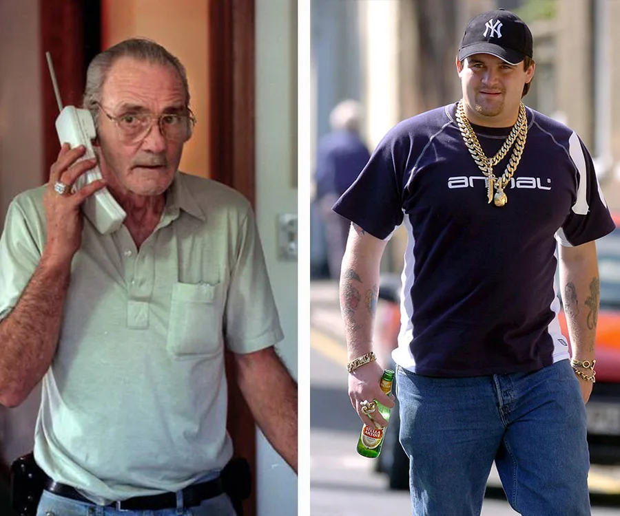 "Two men, one with a vintage mobile phone, the other in casual attire with gold chains and a cap, walking outdoors."