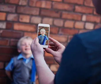 Parent takes a photo of child outside school