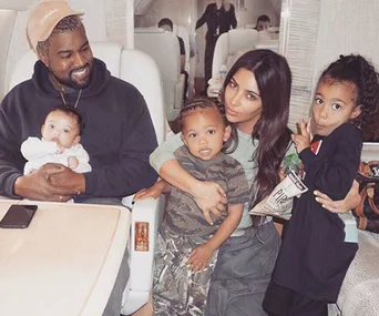 Family sitting together in a private jet, smiling and posing for a photo.