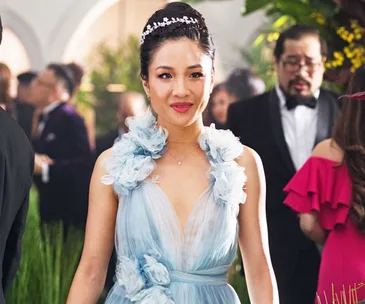 "Constance Wu in a blue gown with floral details at a glamorous event in 'Crazy Rich Asians' scene."