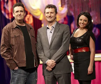 Three people standing together on a TV show set, all smiling at the camera.