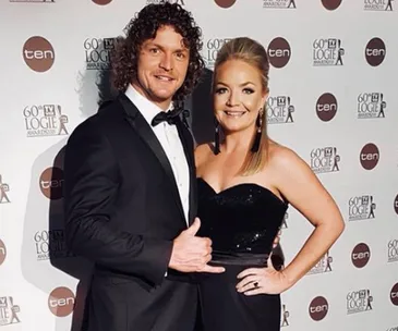 A man and woman in formal attire at the 60th TV Week Logie Awards backdrop, both smiling for the camera.