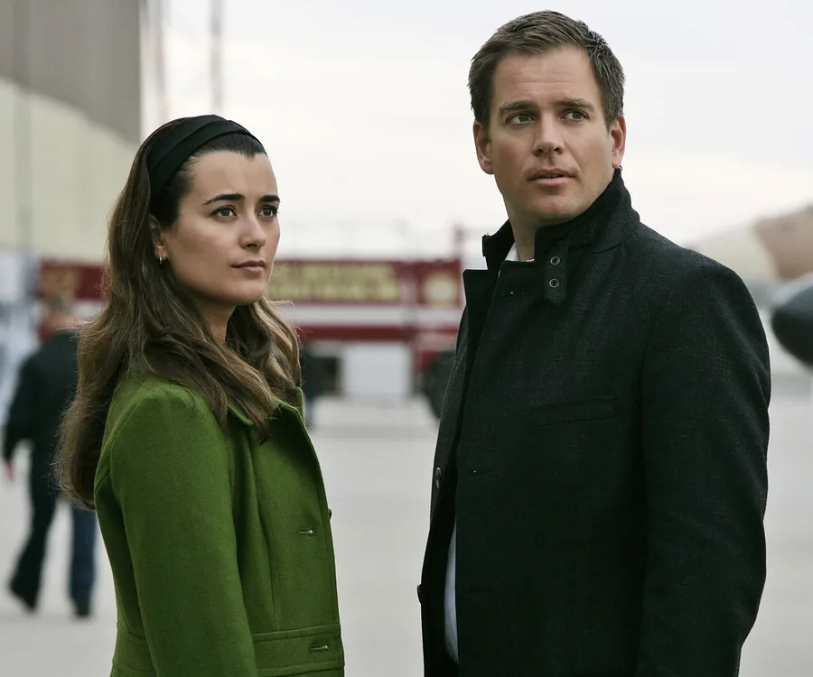 Michael Weatherly and Cote de Pablo as Tony DiNozzo and Ziva David standing outdoors in NCIS scene.