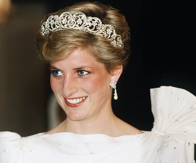 Princess wearing a tiara and elegant white dress, smiling.