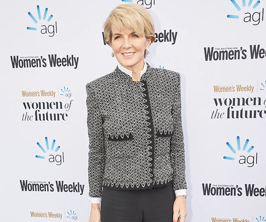 "Person in a patterned blazer on a red carpet at the Australian Women's Weekly event backdrop."