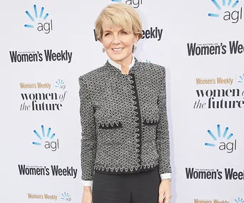 "Person in a patterned blazer on a red carpet at the Australian Women's Weekly event backdrop."