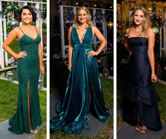Three women in elegant formal gowns at an outdoor event, standing on grass with floral decor in the background.