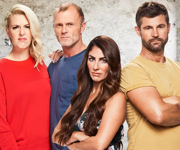 Four people stand confidently against a textured background, conveying determination and team spirit.