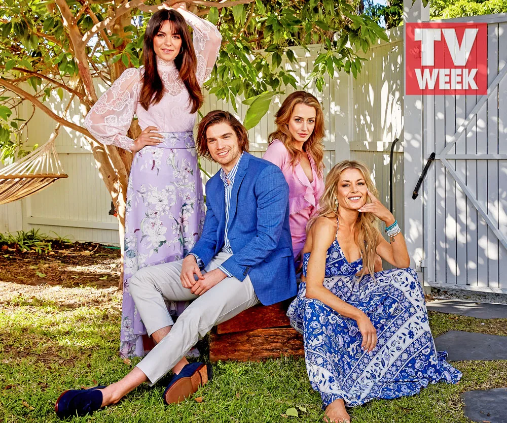 Four people posing outdoors; two women standing, one man and one woman seated, with a "TV WEEK" logo in the background.