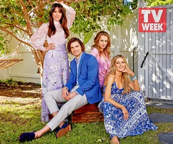 Four people posing outdoors; two women standing, one man and one woman seated, with a "TV WEEK" logo in the background.