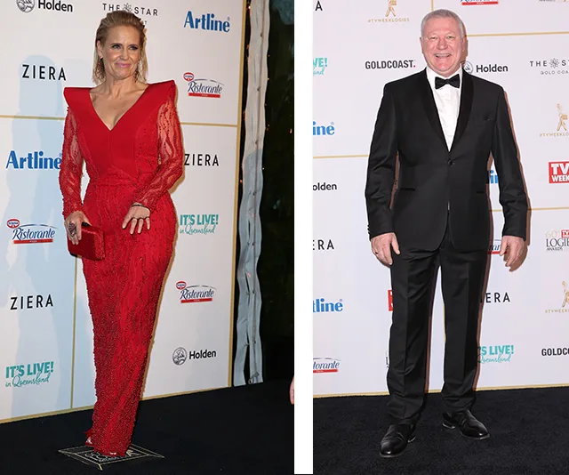Two people pose on a red carpet; one in a red dress, the other in a black suit and bow tie, against a branded backdrop.