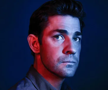 Portrait of a man with blue and red lighting, gazing to the side.