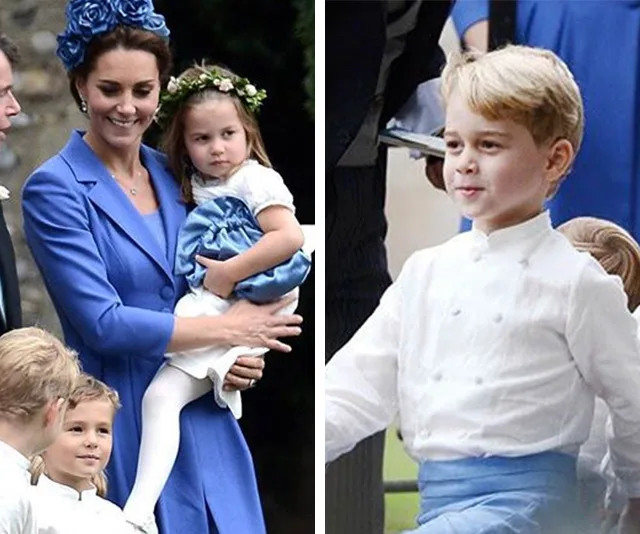 A woman in blue holds a girl in a white and blue dress; a boy in white and blue stands smiling.