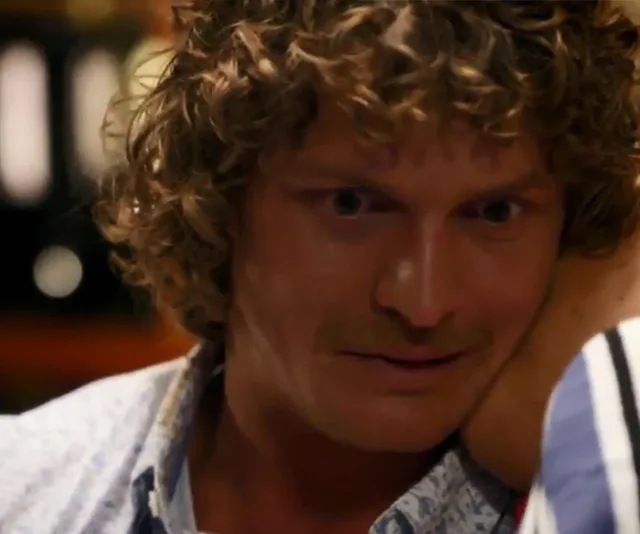 Close-up of a man with curly hair and a mustache in an emotional moment from "Bachelor Australia 2018" finale.