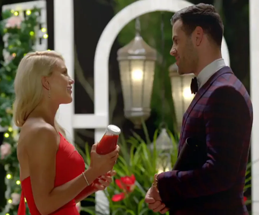 'The Bachelorette Australia' premiere: A woman in a red dress holds a jar, smiling at a man in a suit outdoors.
