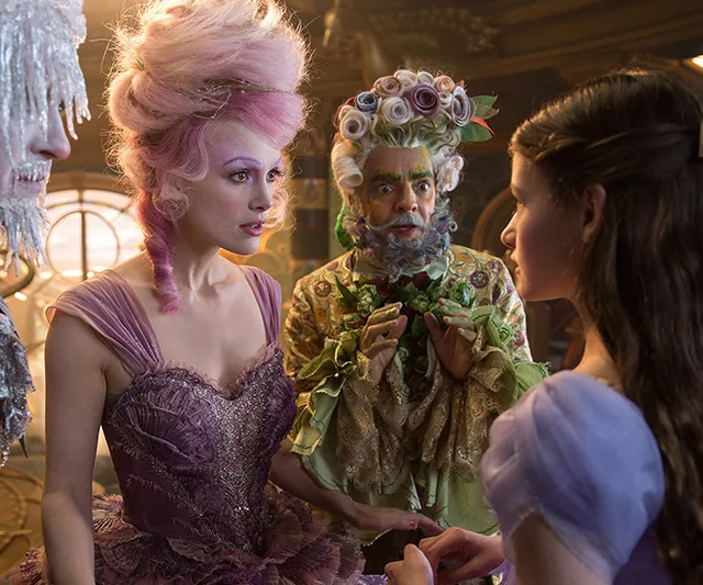 Characters in elaborate costumes from Disney's "The Nutcracker" movie engaged in a conversation.
