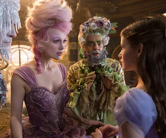 Characters in elaborate costumes from Disney's "The Nutcracker" movie engaged in a conversation.