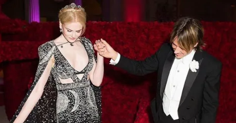 Nicole Kidman and Keith Urban dressed elegantly, holding hands on a red carpet event.