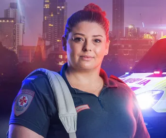 Paramedic in uniform with city skyline and ambulance in background.